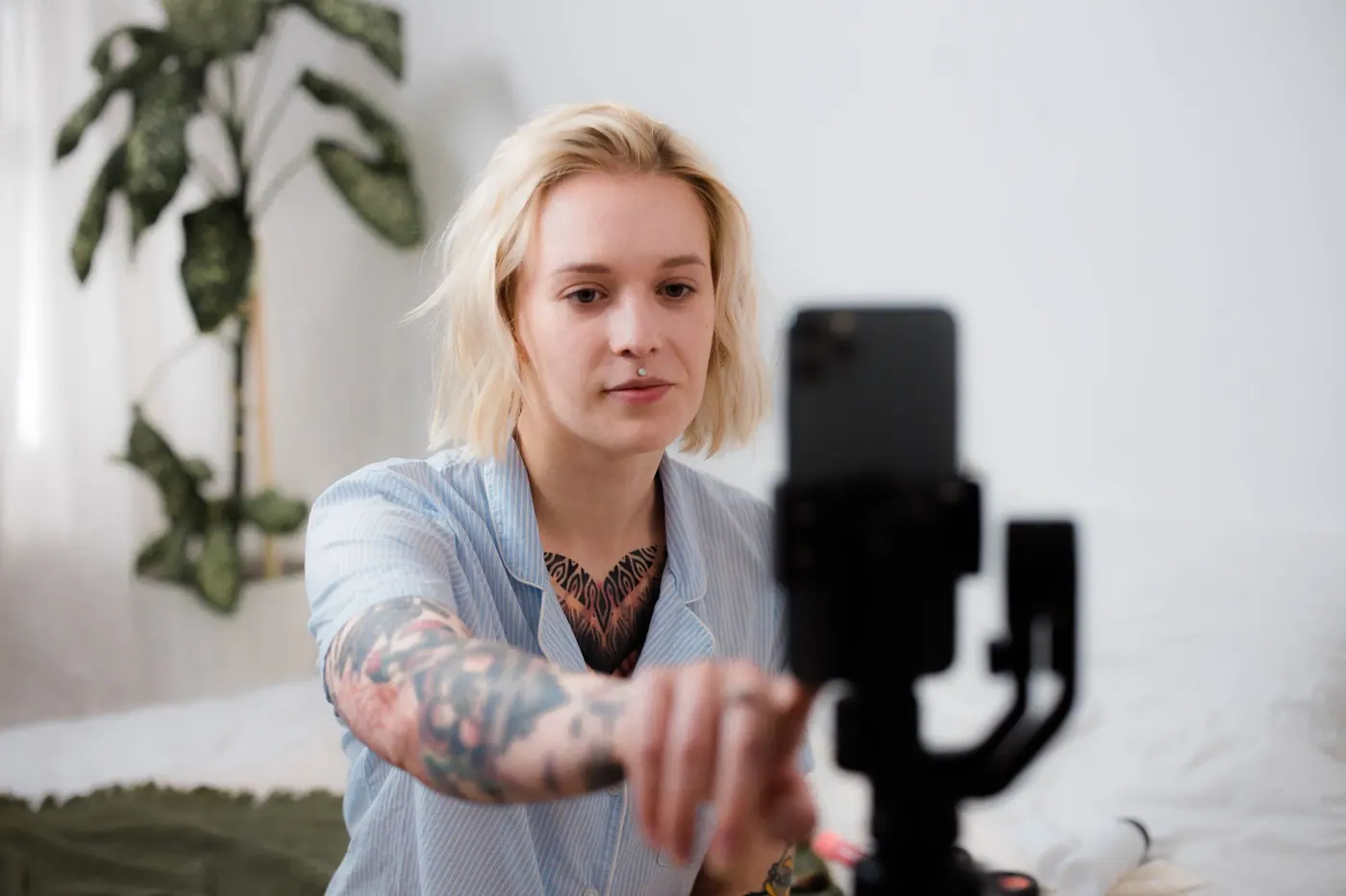Eine tätowierte Creatorin nutzt ihr Smartphone